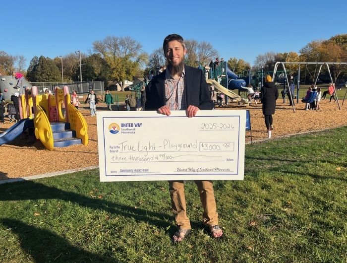 Principal Zach Schubert with Big Check from United Way of Southwest Minnesota