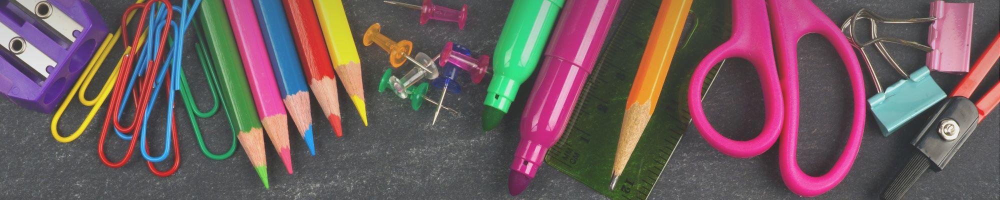 Pictures of school supplies on chalkboard background