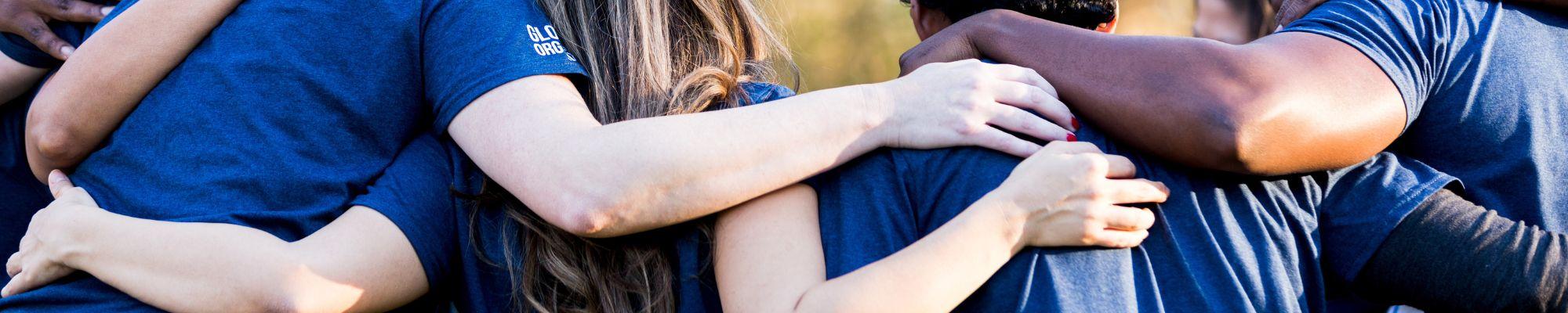 diverse group of people with arms around each other