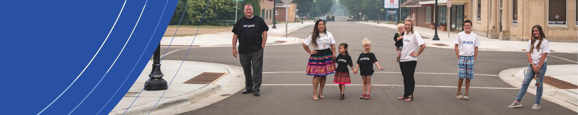 Group of diverse individuals standing in the street in Live United t-shirts